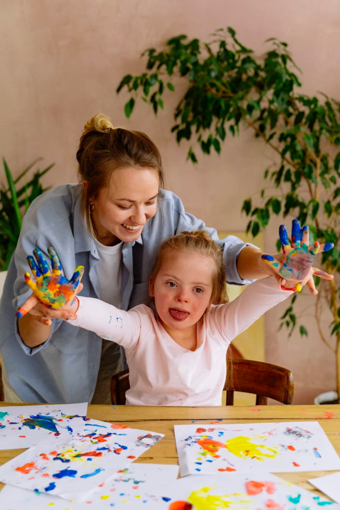 photo of kid painting with teacher