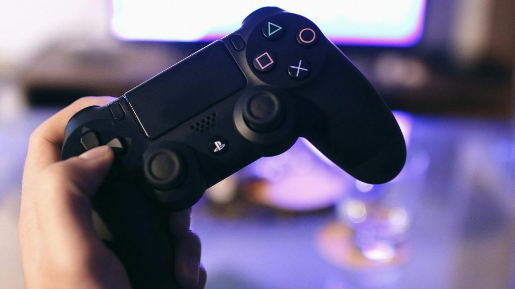 person holding sony ps4 dualshock 4 controller to represent gender diversity in video games